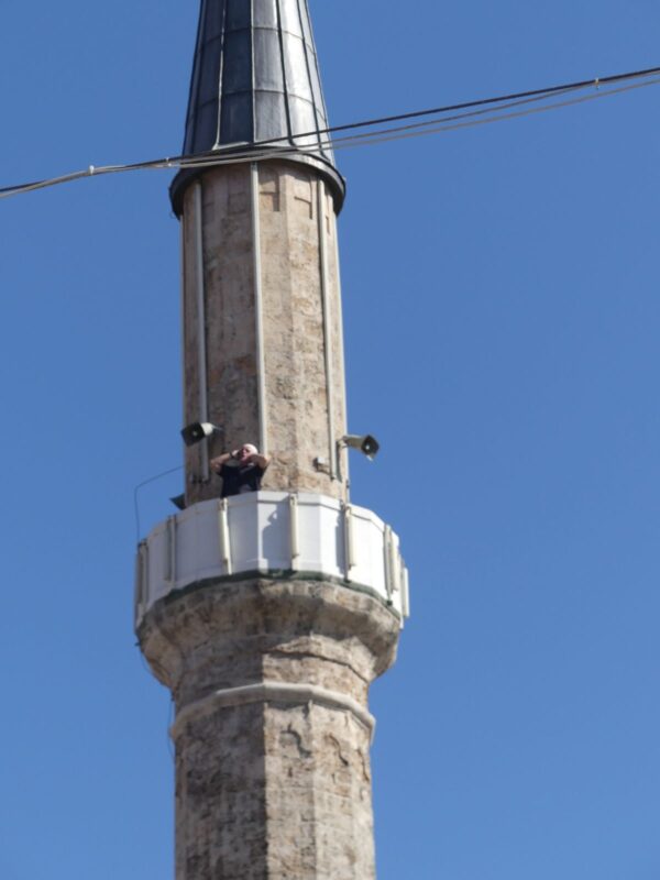 Muhezin auf Minaret ruft zum Gebet