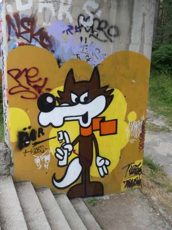 Graffiti an der Bobbahn von Vučko, dem Maskottchen der Olympischen Winterspiele 1984
